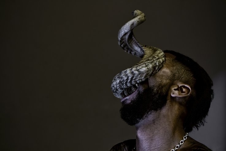 Eine Person mit einer schlangenähnlichen Kreatur, die aus ihrem Mund kommt