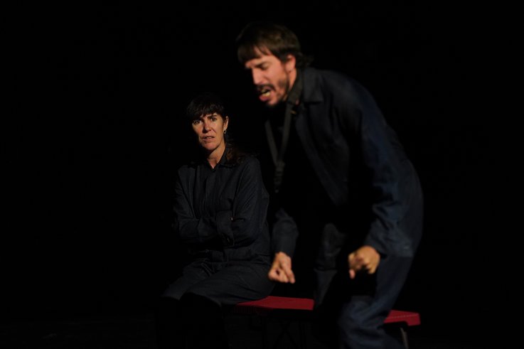 Ein Mann im Vordergrund ballt die Faust, während eine Person im Hintergrund ihn beobachtet