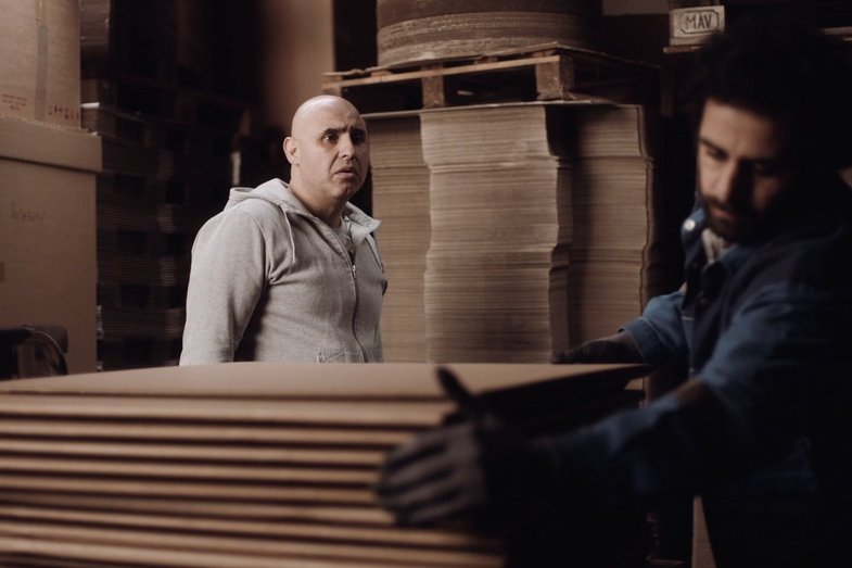 Two men are working with boxes.