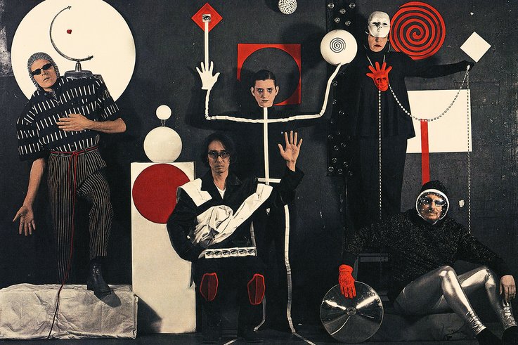 Photo of the band Vanishing Twin: Five people look towards the camera, various geometric shapes are found on the people and in the background.