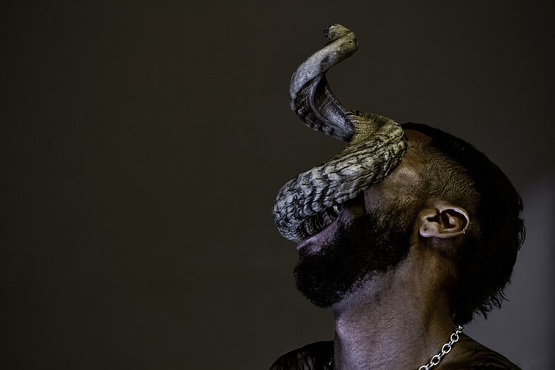 A person with a snake-like creature coming out of their mouth