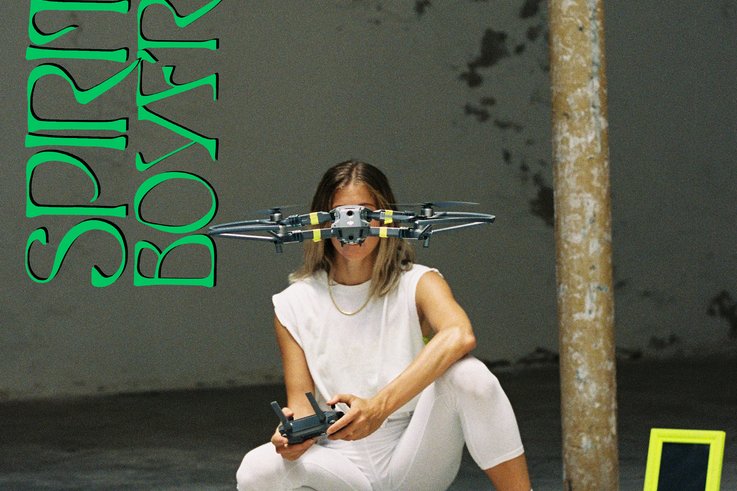 A person crouching lets a remote-controlled quadro-copter fly.