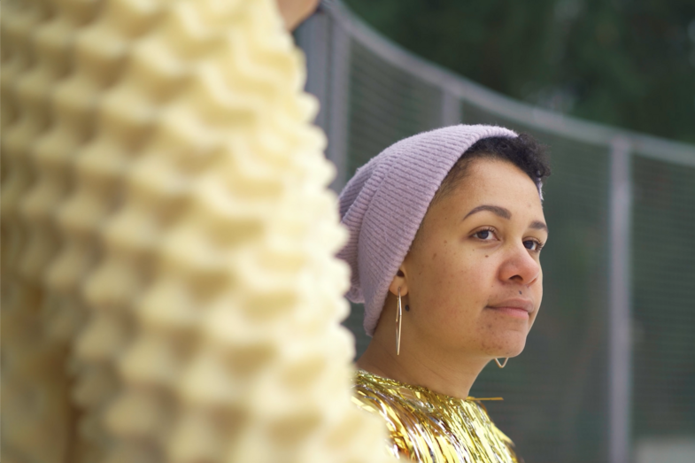 Foto von Olivia Wenzel in einem Lametta-Kostüm. Sie trägt eine Mütze.